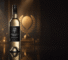 Bottle of Sidewood Sauvignon Blanc on a reflective surface with a golden award statue in the softly blurred background.