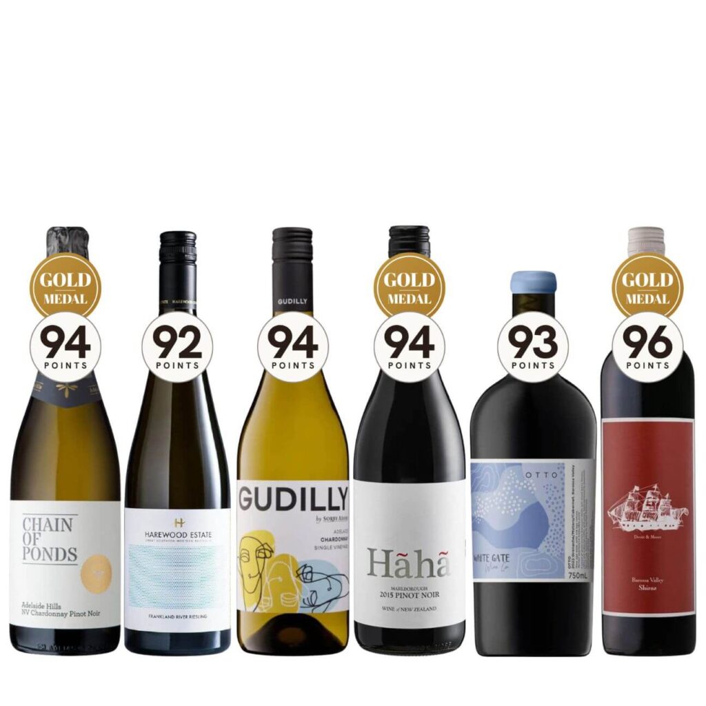Six wine bottles in a row with gold medal seals on top, labels read Chain of Ponds, Harewood Estate, Gudili(y), Hāha Pinot Noir, White Gate, and a sailing-ship bottle, on a white background.